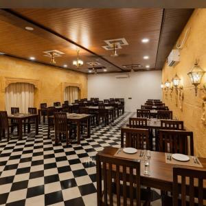 a restaurant with wooden tables and chairs and a checkered floor at Desert Galaxy Camp - A Family Luxury Camp in Jaisalmer