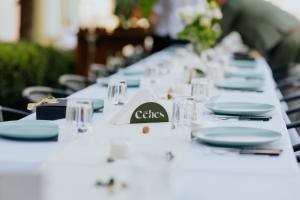 a long table with plates and glasses on it at Céhes Guesthouse in Târgu Secuiesc