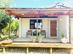 a pergola with potted plants on a wooden deck at Sanctuary Guesthouse in Kimberley