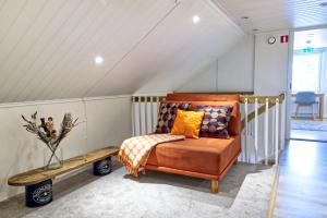 an attic room with a couch and a bench at Hotel Hiisi Hill in Jämsä
