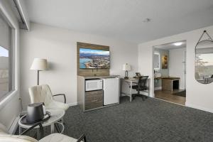 a living room with a kitchen and a desk with chairs at Americas Best Value Inn Polson in Polson