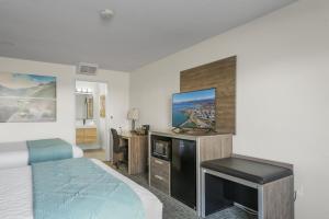 a hotel room with a bed and a flat screen tv at Americas Best Value Inn Polson in Polson