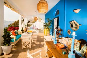 a living room with blue walls and a table and chairs at Seafront Casa Azul Villa - Getaway in Kalymnos in Kalymnos