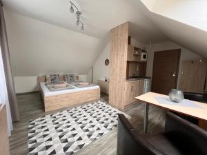 a attic room with a bed and a table at Apartman Valnela in Veľká Lomnica