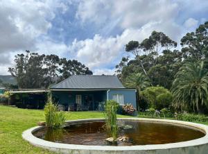 a house with a pond in front of it at Shabach Farm in Hartebeest Rivier