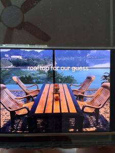 a television screen with a wooden table and chairs at Turtle Nest in Khao Tao