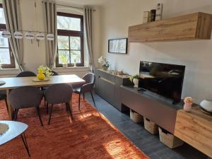 a living room with a dining table and a tv at City-Apartment 1 in Bernburg