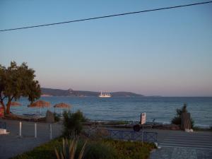 a boat in the ocean with a sail boat in the distance at Oasis studios in Psili Ammos