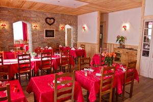 een eetkamer met rode tafels en stoelen met rode tafelkleden bij L'Hermitage in Brides-les-Bains