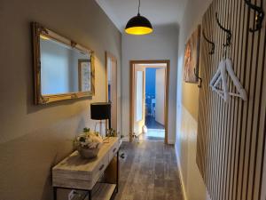 a hallway with a table and a mirror on the wall at City-Apartment 1 in Bernburg