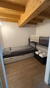 a small room with a bed and a wooden ceiling at La Primula Panoramic View - Valmalenco in Chiesa in Valmalenco
