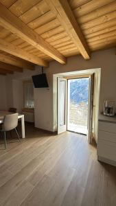 a living room with a large window and a table at La Primula Panoramic View - Valmalenco in Chiesa in Valmalenco