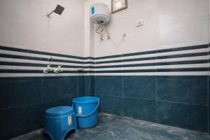 a bathroom with two blue trash cans and a shower at Hotel Bhavishyaa Vrindavan in Vrindāvan