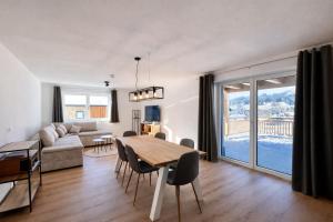 a living room with a couch and a table and chairs at Staminé in Hochfilzen