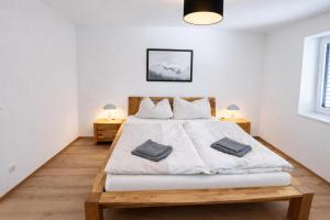 a bedroom with a large white bed with two tables at Staminé in Hochfilzen
