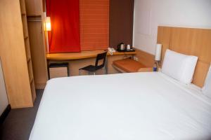 a bedroom with a bed and a desk and a table at Delta Continental Hotel and Suite, Lagos in Lagos +12 photos