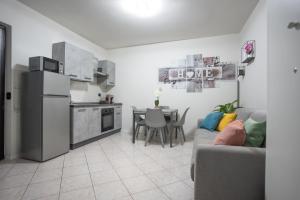 a kitchen and a living room with a couch and a table at Antonella's sweet home AIRPORT ORIO AL SERIO in Stezzano