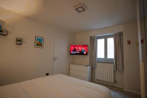a bedroom with a bed and a tv on the wall at Antonella's sweet home AIRPORT ORIO AL SERIO in Stezzano
