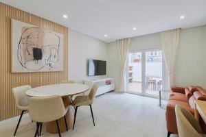 a living room with a table and chairs and a television at Setúbal Serenity Villa II, By Home Match in Setúbal