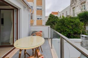 a balcony with a table and chairs on it at Setúbal Serenity Villa II, By Home Match in Setúbal