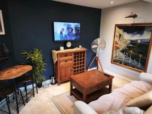 a living room with a couch and a tv on a wall at Groombridge 1 Bed self catered flat, can sleep 2 in Groombridge