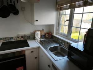 a small kitchen with a sink and a window at Groombridge 1 Bed self catered flat, can sleep 2 in Groombridge