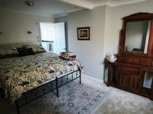 a bedroom with a bed and a dresser and a mirror at Groombridge 1 Bed self catered flat, can sleep 2 in Groombridge