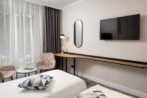 a hotel room with a bed and a desk and a tv at Hotel Soimul in Poiana Brasov
