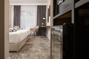 a hotel room with a bed and a table and chairs at Hotel Soimul in Poiana Brasov