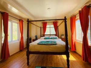 a bedroom with a canopy bed with orange curtains at Perched on a mountain top, breathtaking city view in Kathmandu