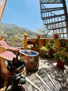 a balcony with chairs and a table and some plants at Perched on a mountain top, breathtaking city view in Kathmandu