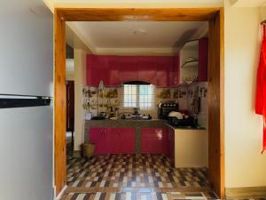 a kitchen with red cabinets and a tile floor at Perched on a mountain top, breathtaking city view in Kathmandu