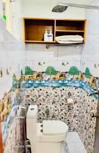 a bathroom with a toilet and a mosaic wall at Perched on a mountain top, breathtaking city view in Kathmandu +22 photos