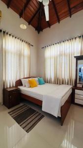 a bedroom with a large bed with white curtains at Eco Villa Resort in Negombo