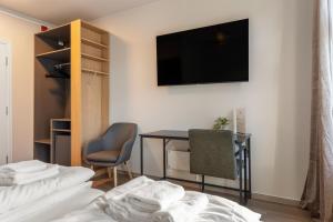 ein Hotelzimmer mit Schreibtisch und Fernseher an der Wand in der Unterkunft Strandgata Hotel in Haugesund + 7 Fotos
