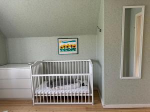 a white crib in a room with a mirror at Dalagård i Insjön in Insjön