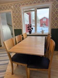a wooden table and chairs in a room with a window at Dalagård i Insjön in Insjön