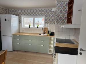 a kitchen with a white refrigerator and a window at Dalagård i Insjön in Insjön