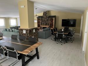 a living room with a table and chairs and a tv at Villa Meraki experiencia in San Miguel de Corneja