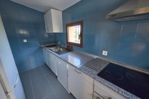a blue kitchen with a sink and a window at Villa Meraki experiencia in San Miguel de Corneja