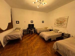 a room with three beds and a television in it at PH Palermo HollyHouse in Buenos Aires