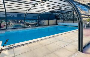 an indoor swimming pool with an arched roof at Maison Avec Piscine in Coutances
