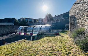 a bus is parked next to a brick wall at Maison Avec Piscine in Coutances