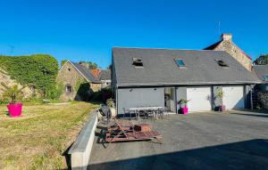 a house with a table and chairs in front of it at Maison Avec Piscine in Coutances +11 photos