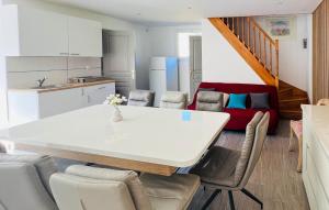 a kitchen and living room with a white table and chairs at Maison Avec Piscine in Coutances