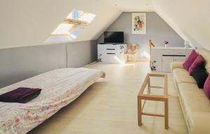 a attic bedroom with a bed and a couch at Maison Avec Piscine in Coutances