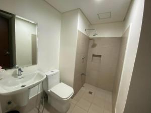 a white bathroom with a toilet and a sink at Gradient Sky in Manila