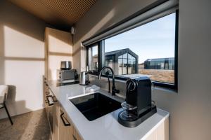 a kitchen with a sink and a large window at Green Geysir Cottage in Torfastaðir +19 photos
