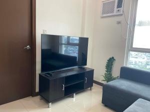 a living room with a large flat screen tv at Gradient Sky in Manila