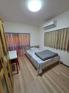 a bedroom with a bed and a desk in it at Daizaifu Guest House 1 in Dazaifu
